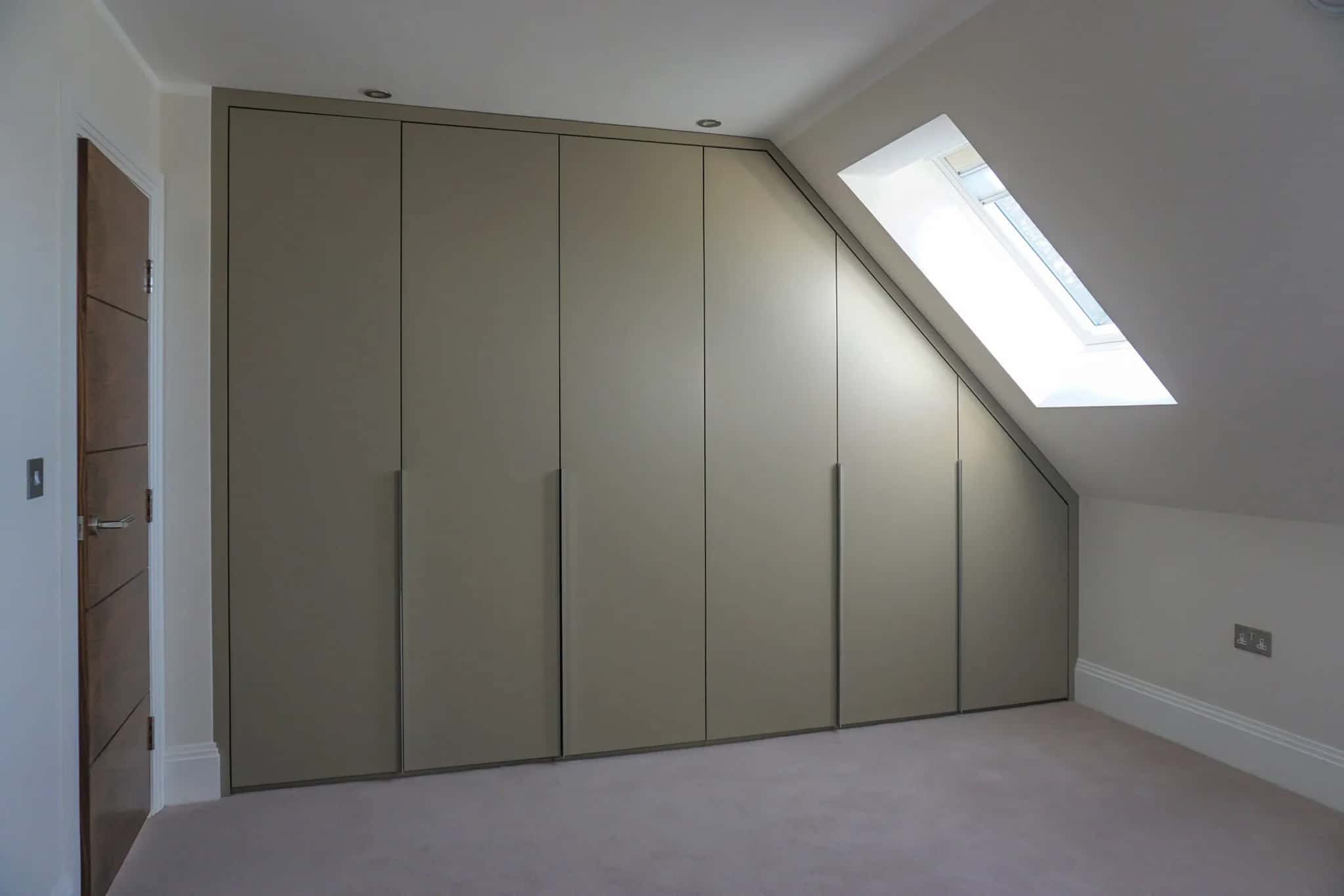 Sage green fitted wardrobes with slanted end following a sloping loft ceiling