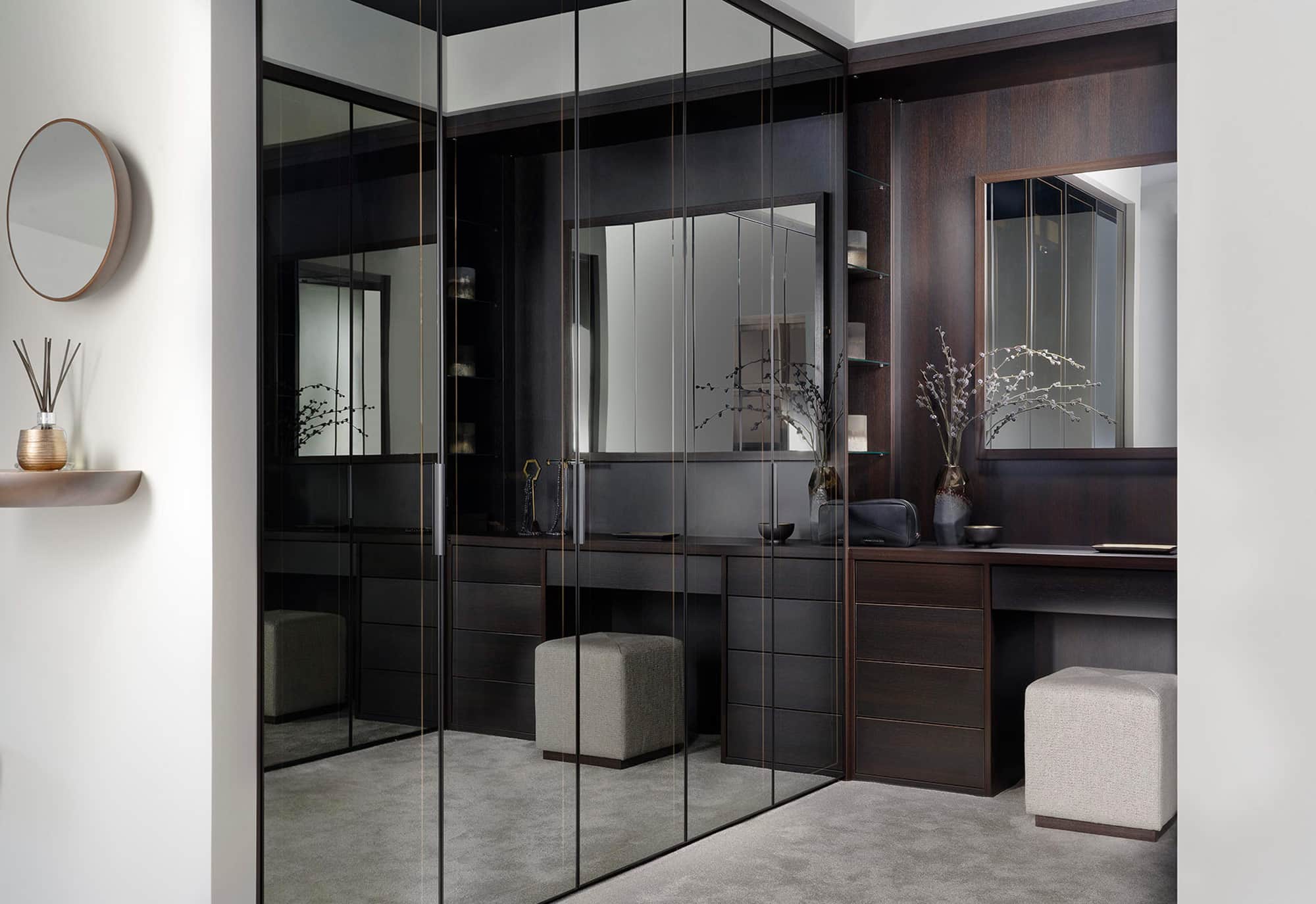 Dark mirrored glass wardrobes in a bespoke dressing room