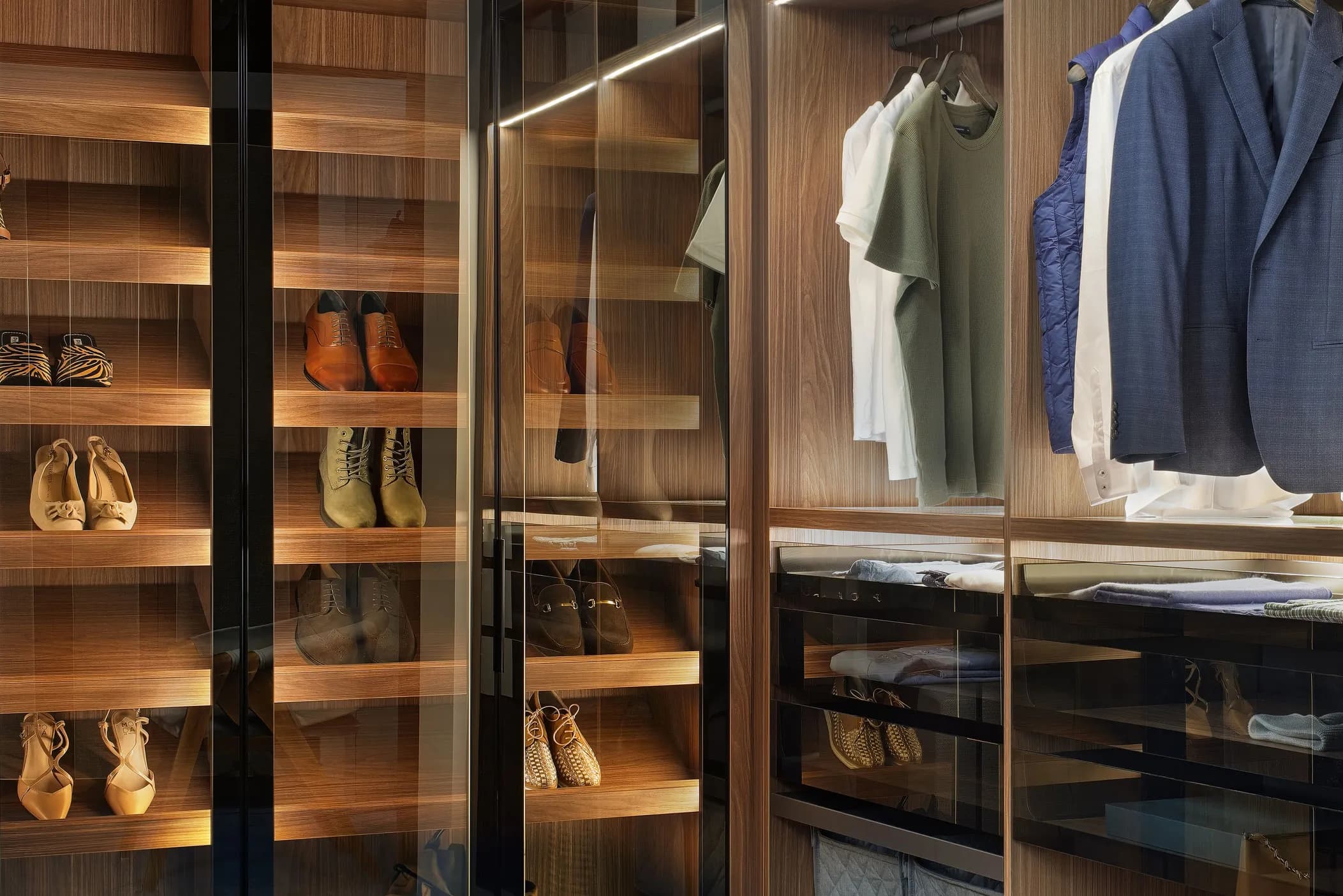 Glass-fronted wardrobe with LED-lit walnut shelves, shoes and hanging clothes