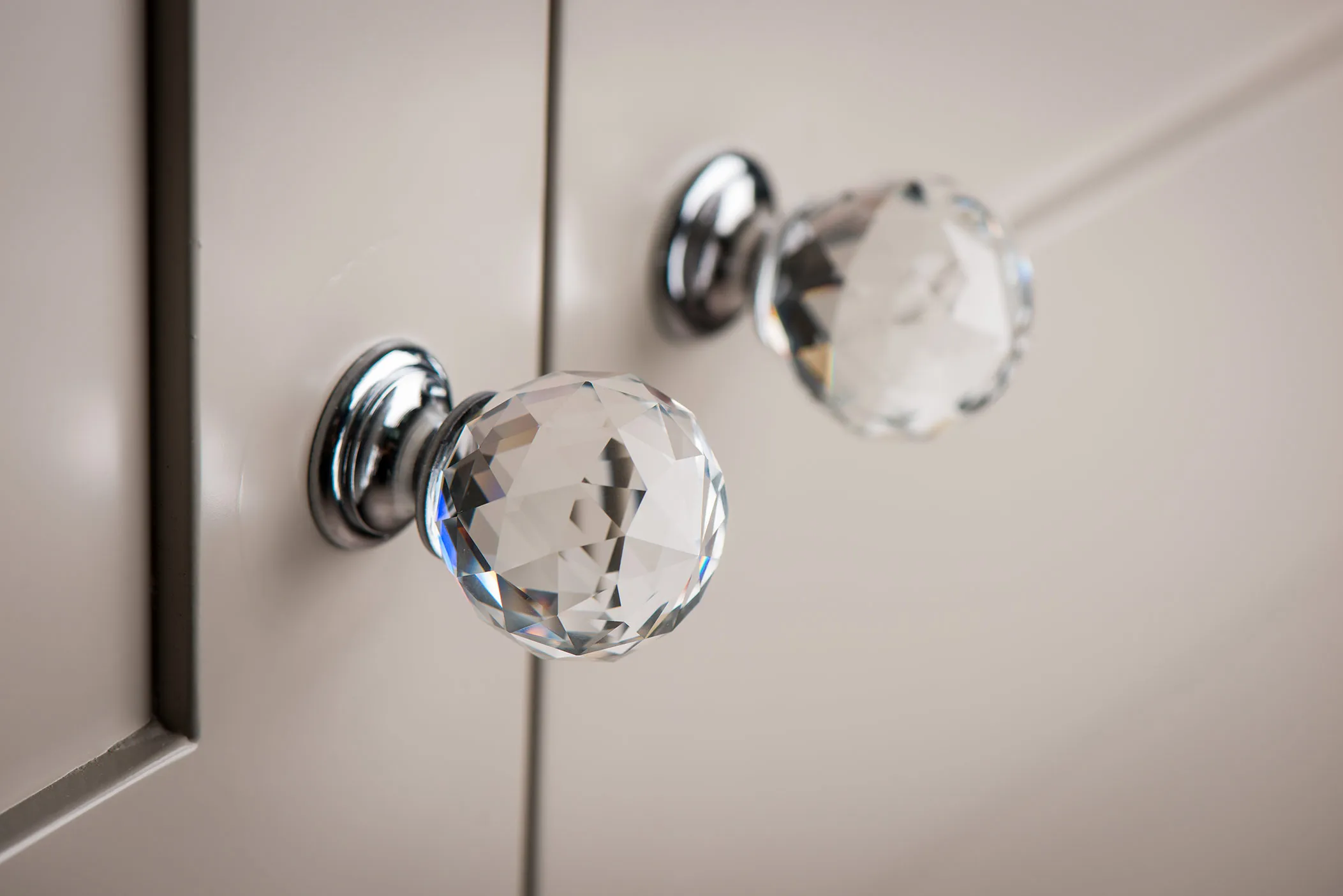Crystal glass door knobs with chrome bases on taupe wardrobe doors