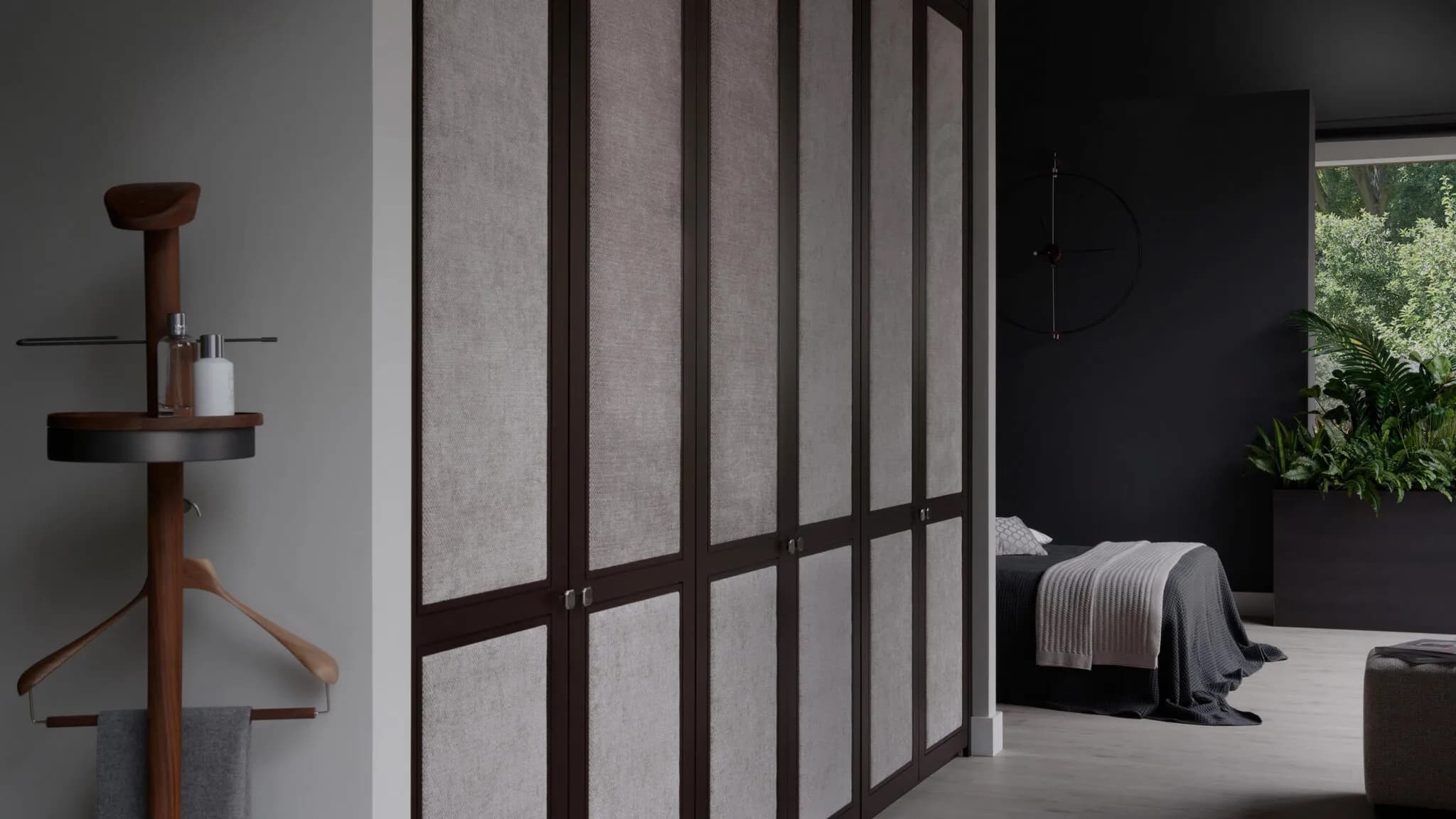 Dark-framed Shaker wardrobe doors with fabric panels beside a modern bedroom