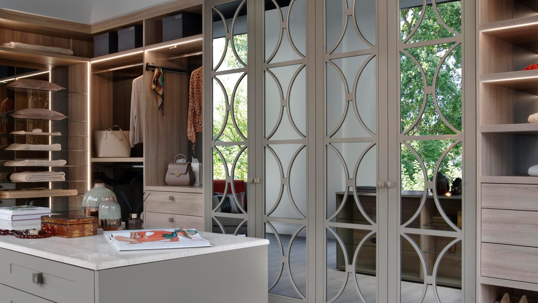 Bespoke mirrored glass wardrobes with decorative frames and interior lighting