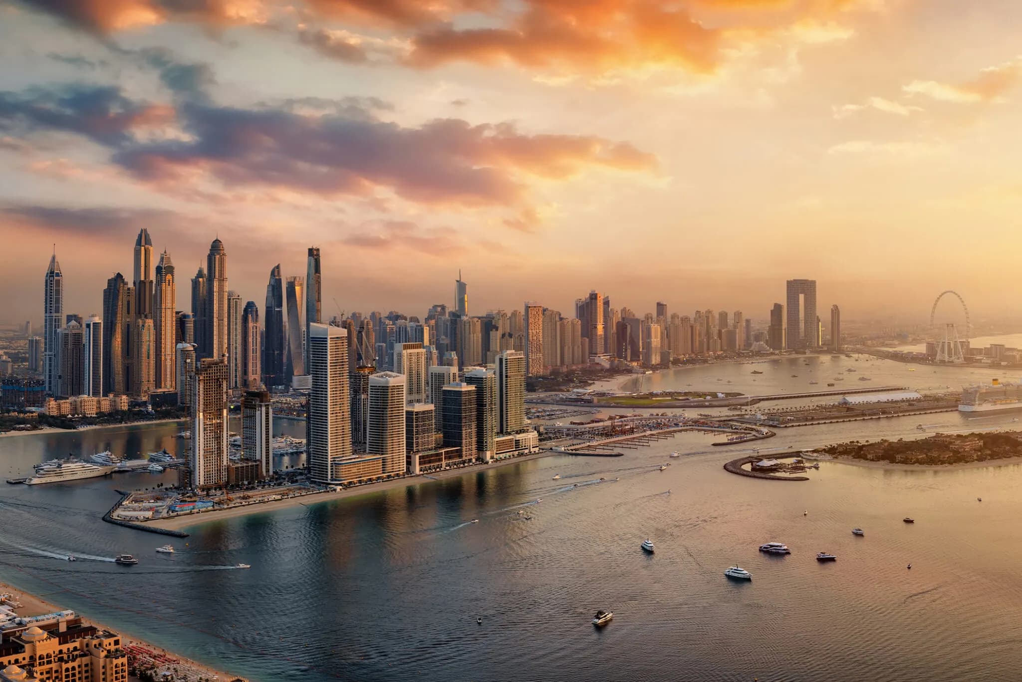 Dubai skyline at sunset with waterfront towers and boats