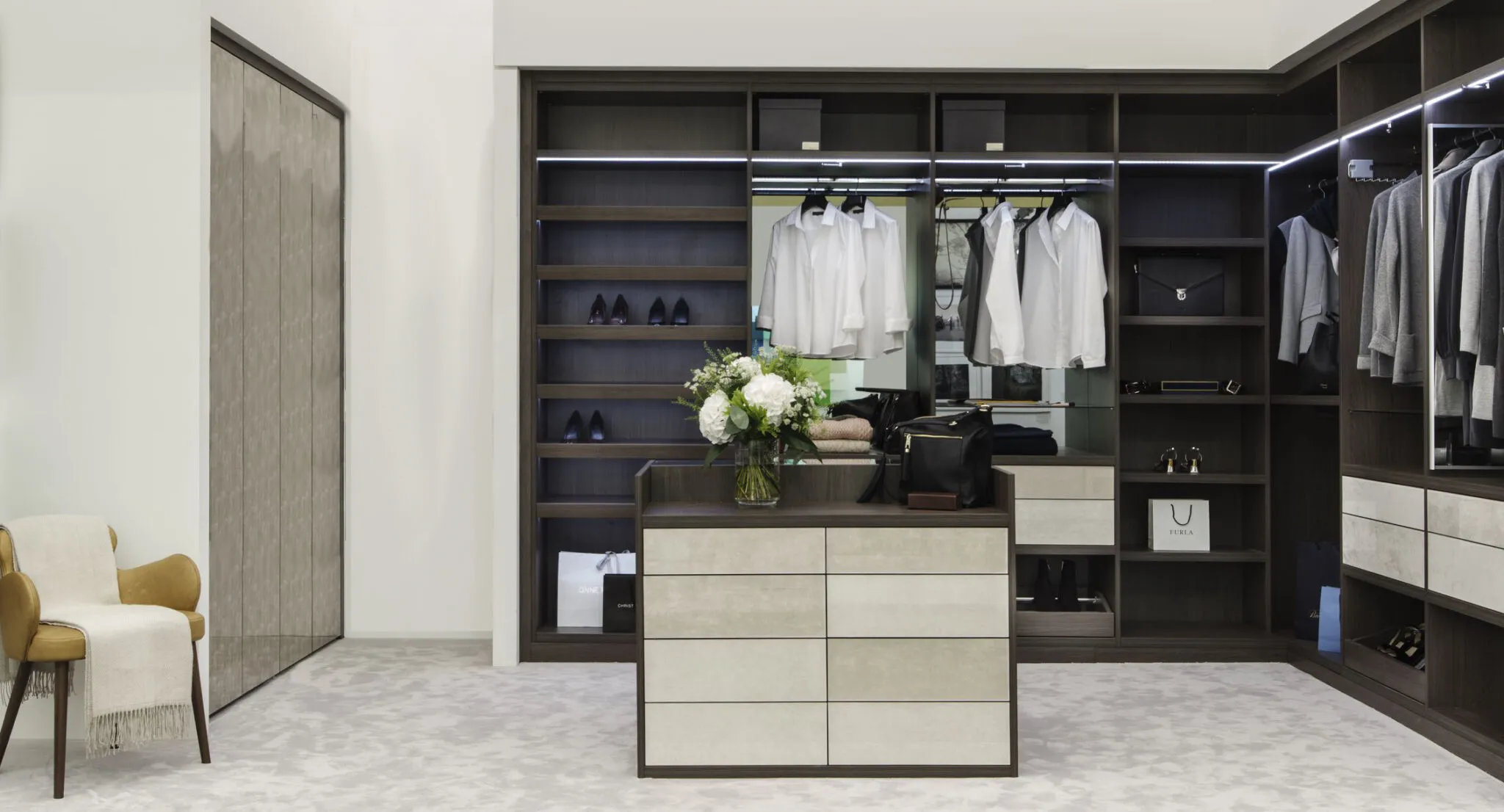 Dressing room with vanity desk, round mirror, table lamps and glass-fronted wardrobes