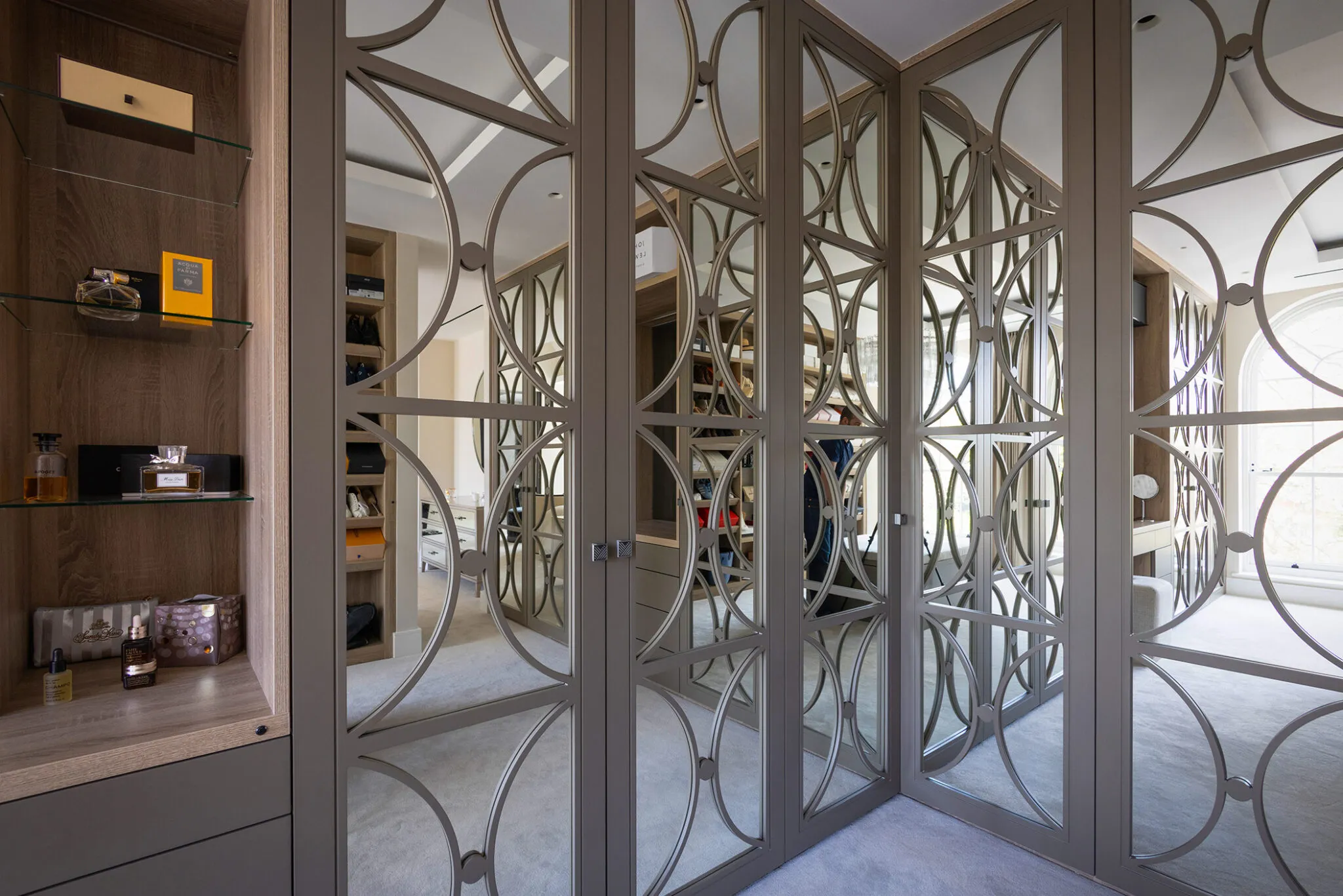 Wardrobe doors with mirror panels and a decorative circular lattice overlay