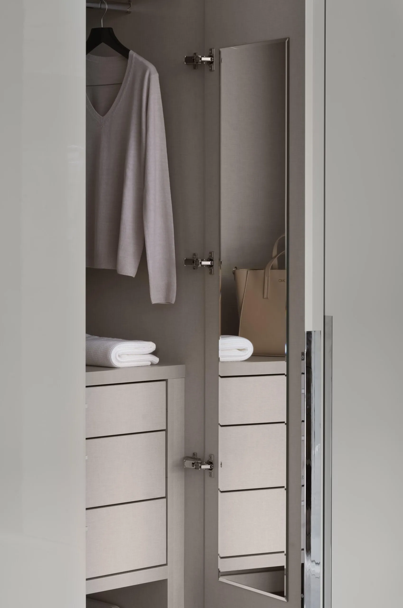 Wardrobe door opened to reveal an internal swivel mirror, drawers and hanging space