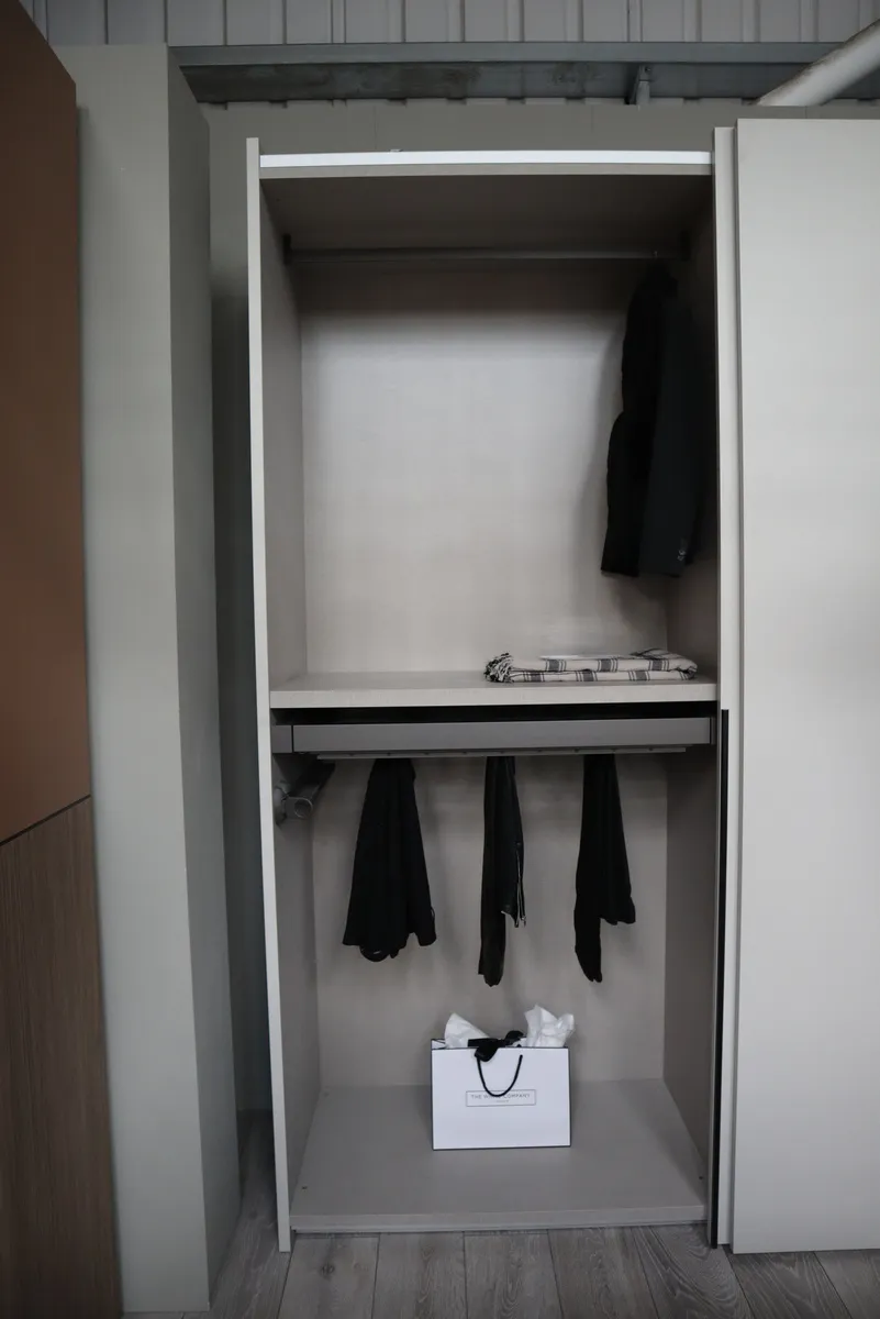 Light grey wardrobe interior with double hanging rails, shelf and clothing