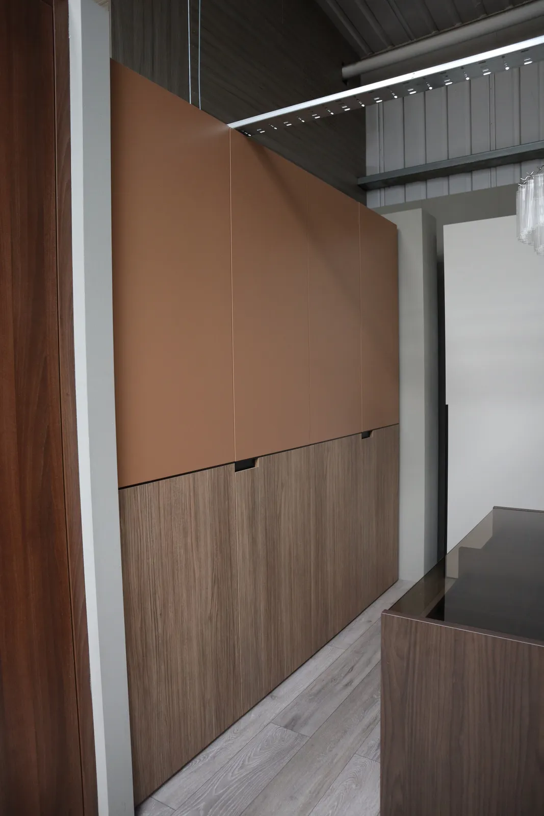 Fitted wall storage with tan leather-effect upper doors and walnut lower doors