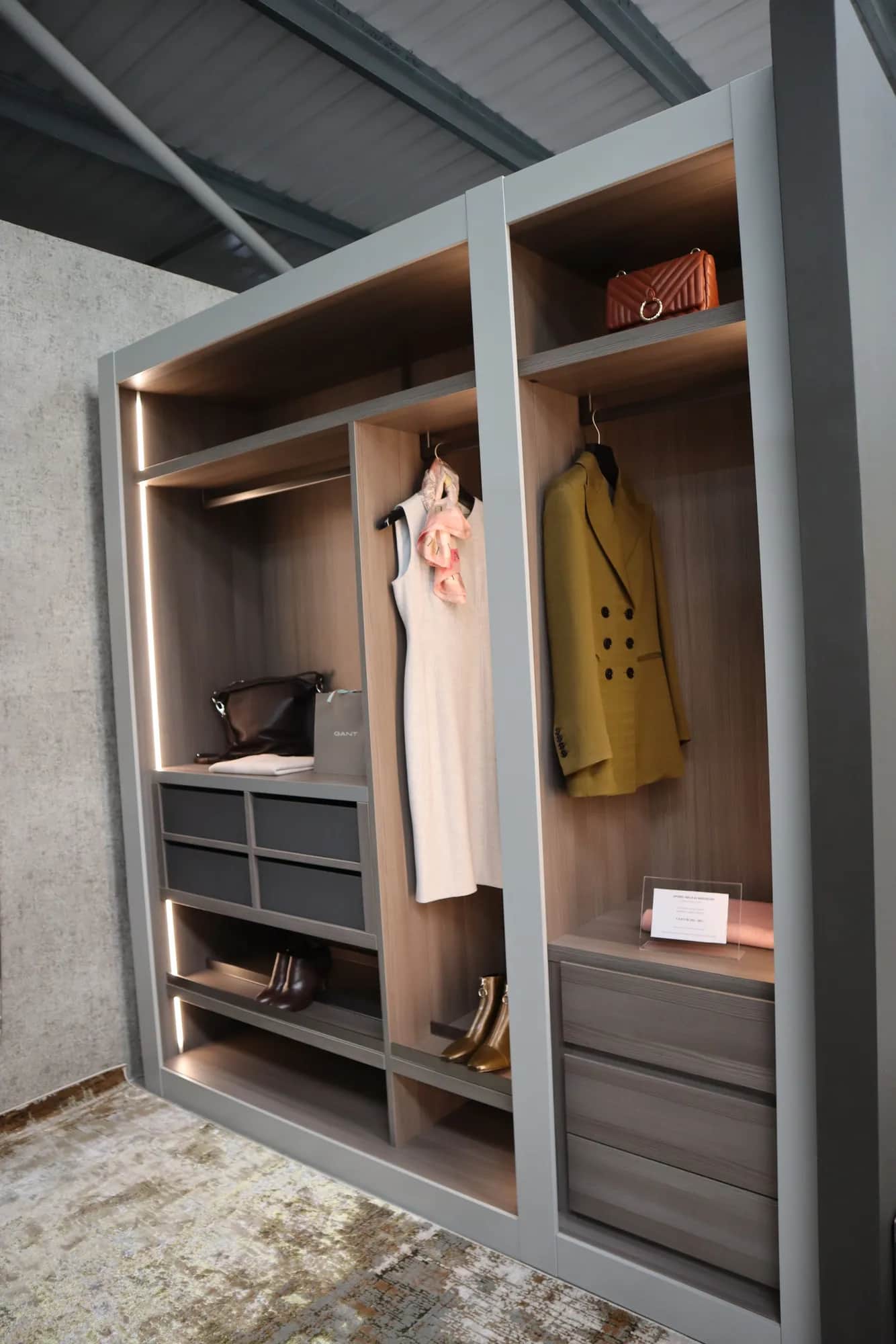 Grey walk-in wardrobe with LED lighting, hanging clothes, drawers and shoe shelves