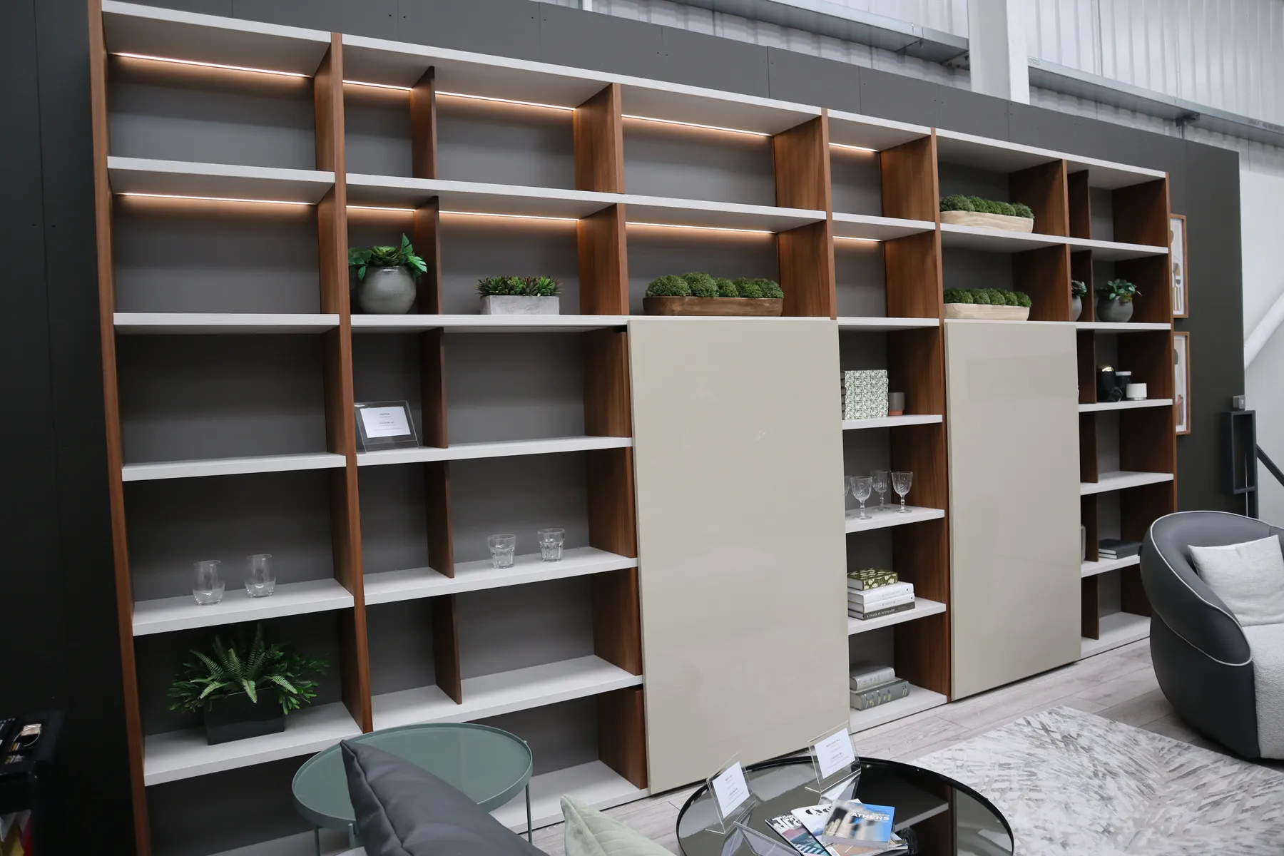 Wall-to-wall oak and white shelving with LED lighting and sliding panels