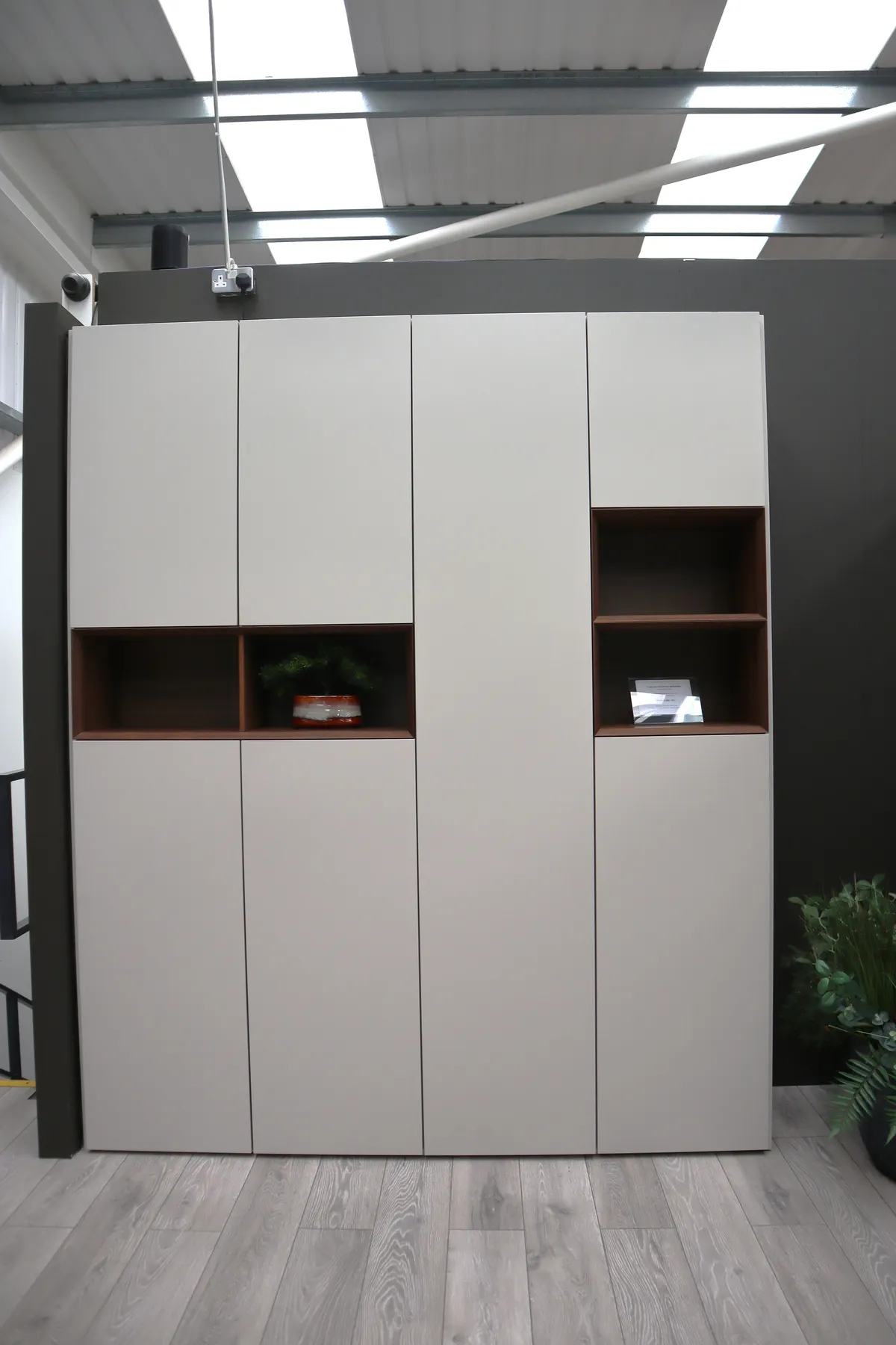 Tall storage unit with closed pale doors and two dark red open recesses