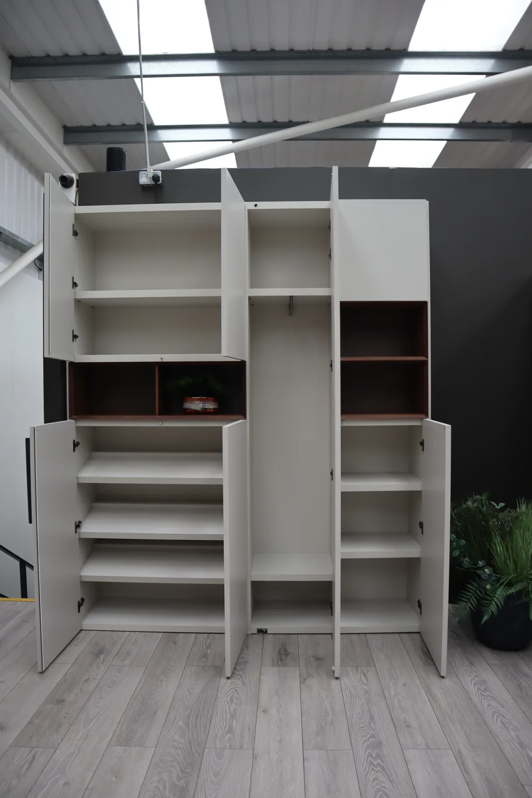 Tall storage unit with doors open showing shelves and a dark red recess