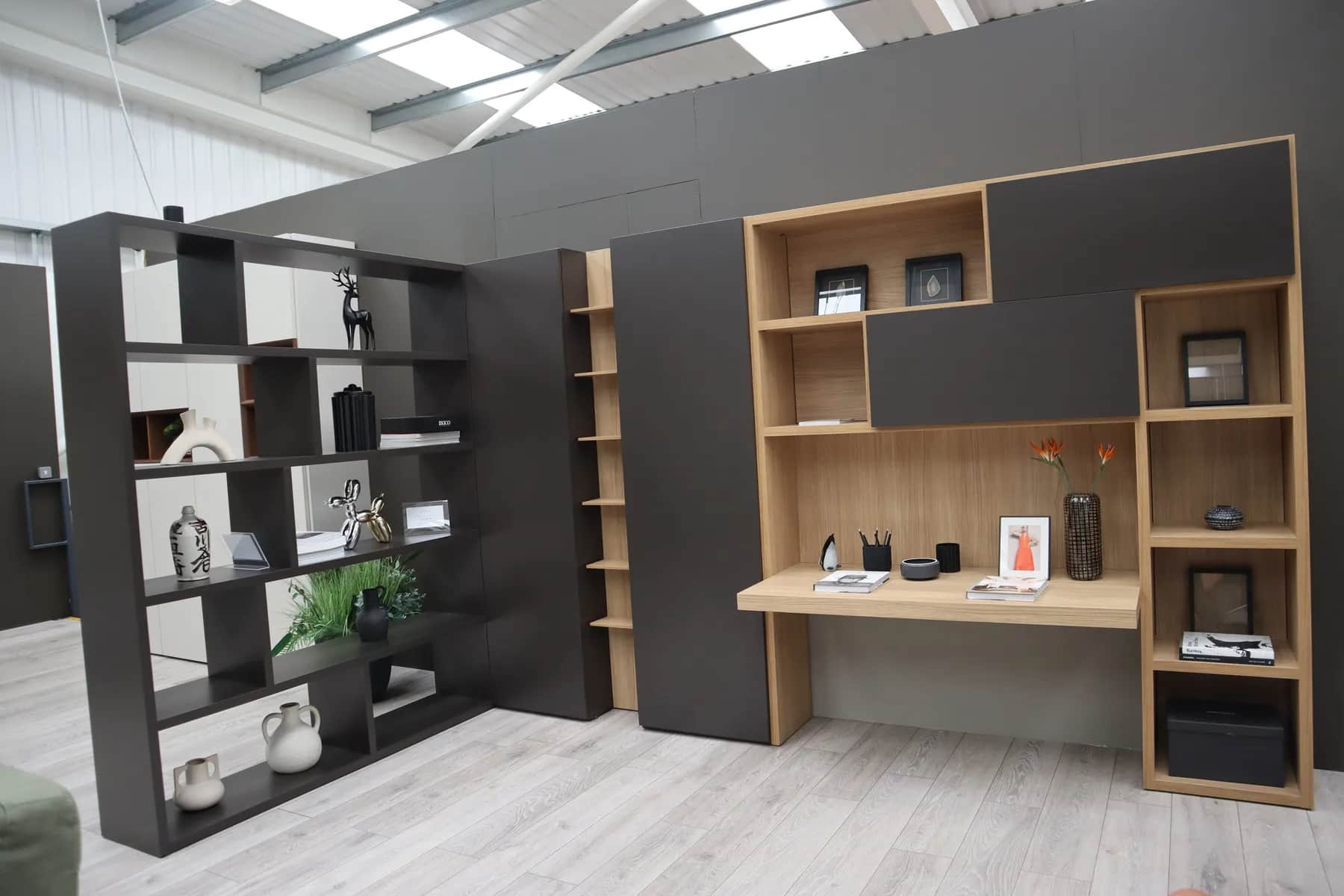 Home office with oak desk, dark storage units, open shelving and bookcase