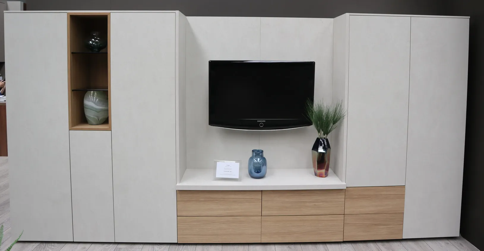 Living room TV unit with closed white doors and oak drawers beneath the television