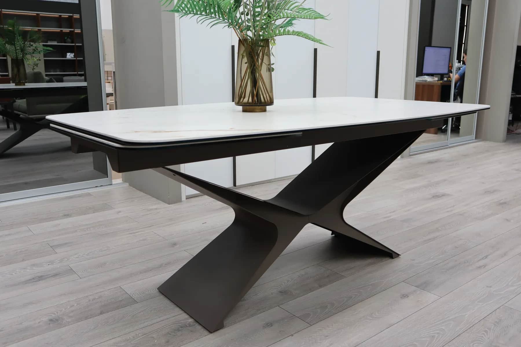 Extending dining table with white marble-effect top and angular dark base