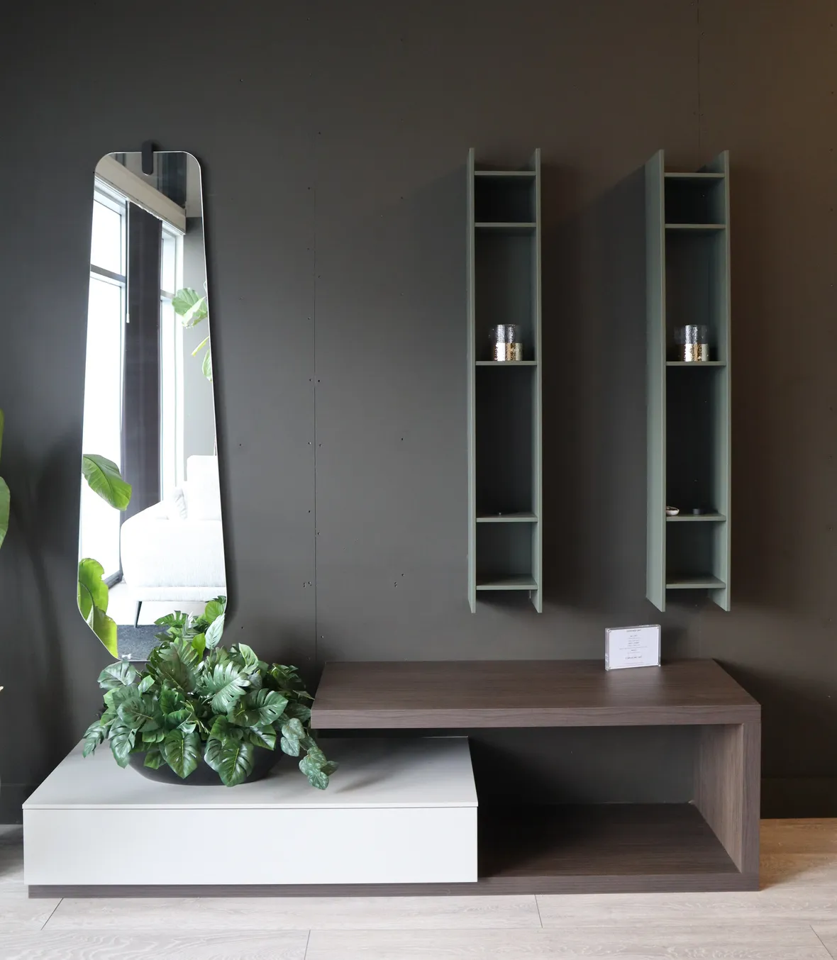Floating wood and white drawer unit with wall mirror and two green shelves