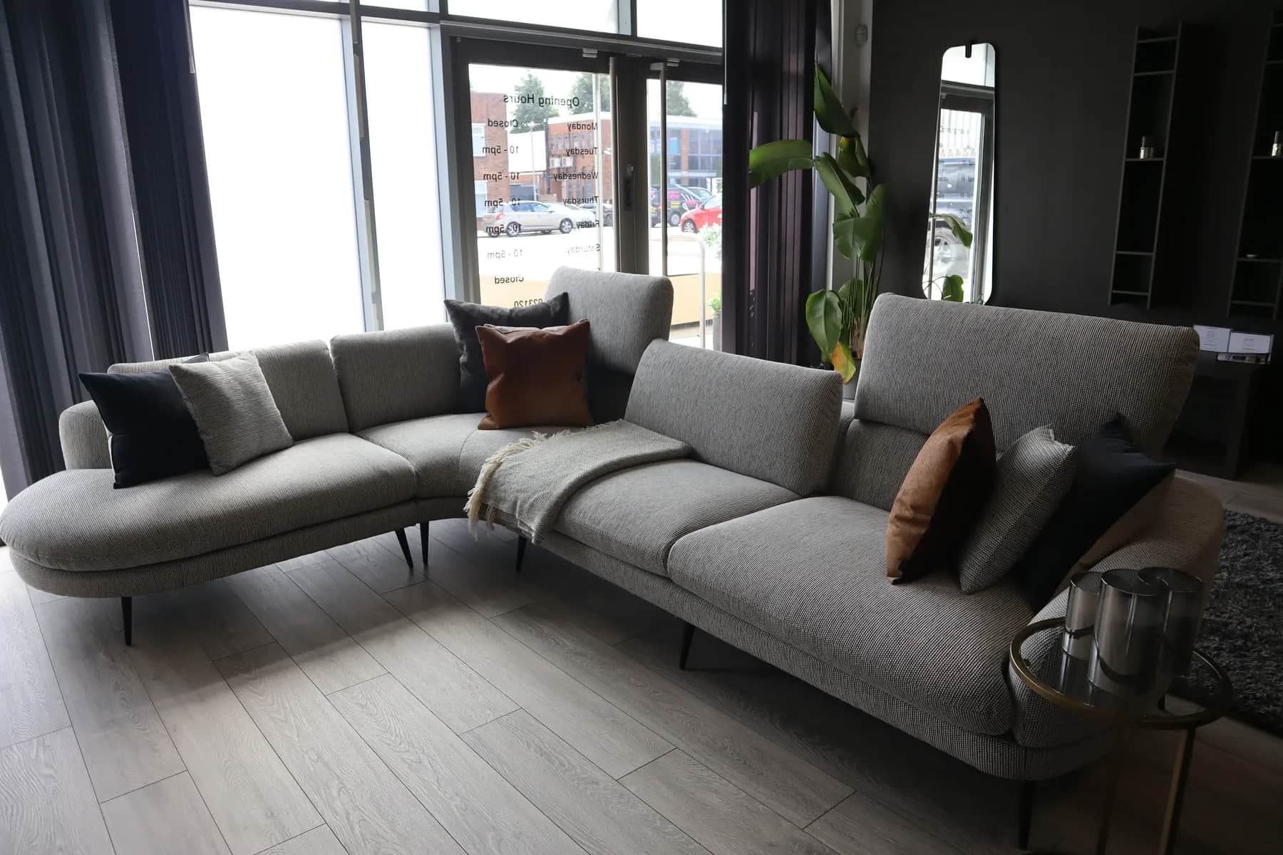 Grey fabric corner sofa with cushions in a showroom