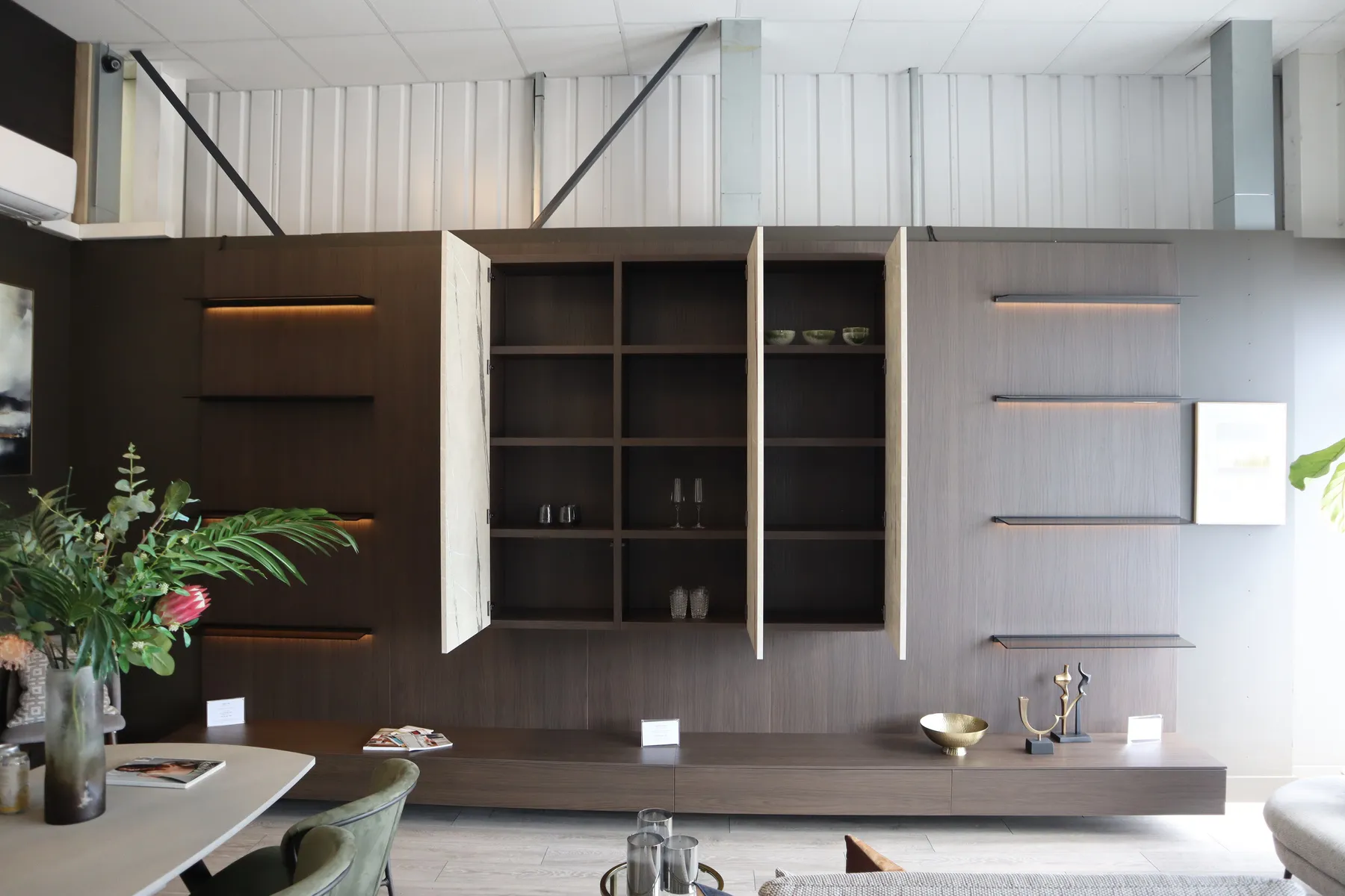 Dark wood living room wall unit with open doors, shelving and LED lighting