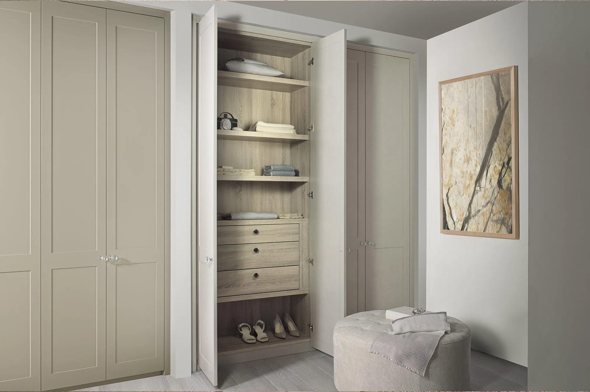 Open Shaker wardrobe door showing oak shelving, drawers and shoe storage