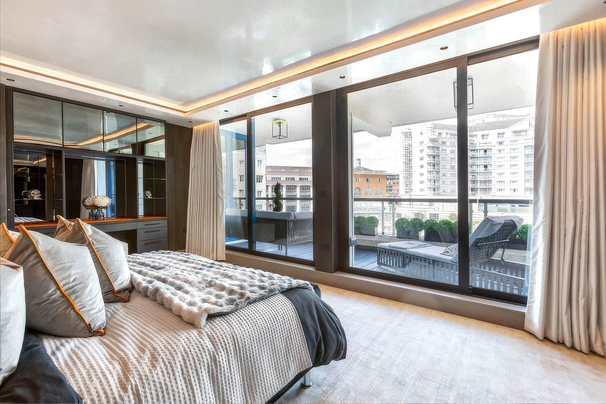 Bedroom with balcony view and mirrored fitted wardrobes with LED lighting