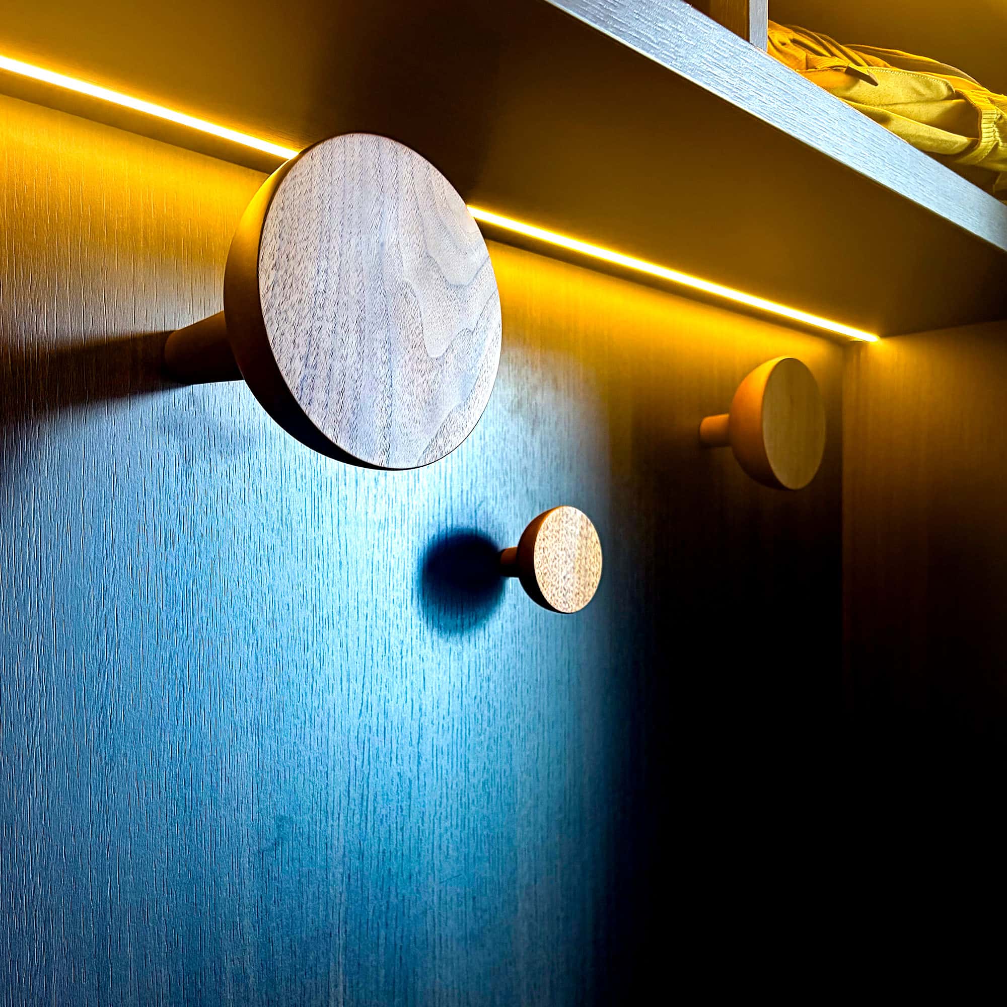Bespoke wooden hanging hooks in a fitted boot room